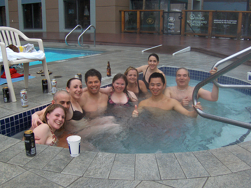 adults drinking beer in hot tub